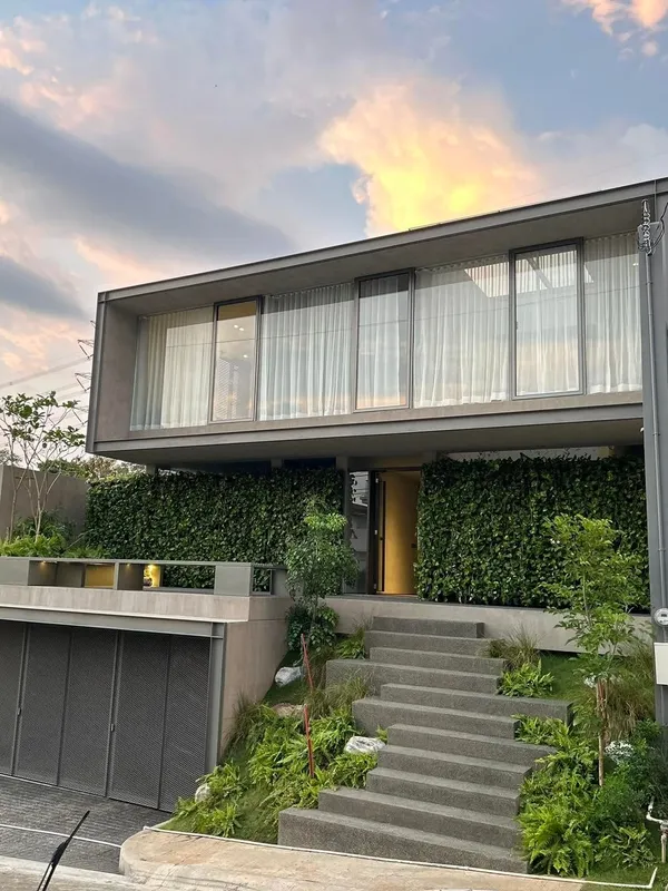 Concrete stairs rising up a sloped front garden of ferns and grasses to a modern house with a vertical garden on its facade, The Terraces at Havila, Taytay